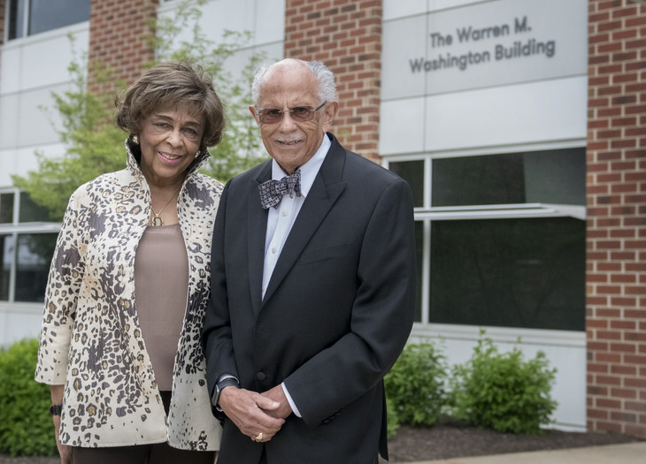 Warren and Mary Washington pose for photos at the entrance to the newly-named Warren M. Washington Building at Penn State's Innovation Park
